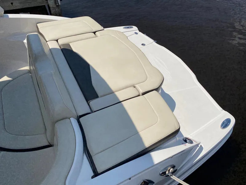 Slide: The Image of 2019 Chaparral 246 SSi boat with beige seating, docked by the water. - 5