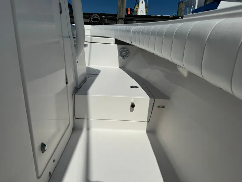 Slide: The Image of 2009 Regulator 32 Forward Seating boat interior with white upholstery and storage compartments. - 13
