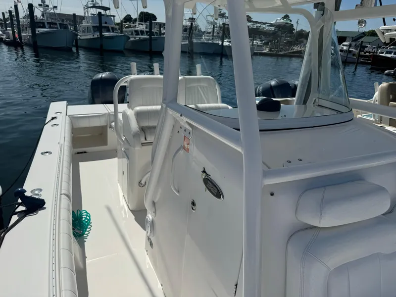 Slide: The Image of 2009 Regulator 32 Forward Seating boat docked at marina, showcasing spacious deck and seating. - 23