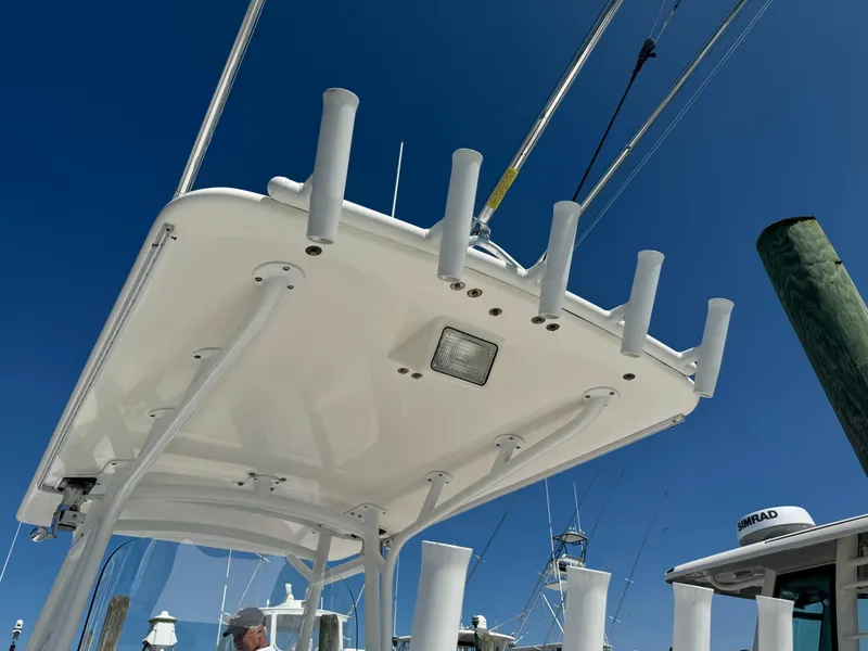 Slide: The Image of 2009 Regulator 32 Forward Seating boat with rod holders and T-top under clear blue sky. - 47