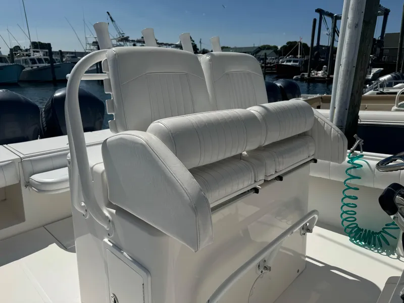 Slide: The Image of 2009 Regulator 32 Forward Seating boat with white cushioned seats, docked at marina. - 9