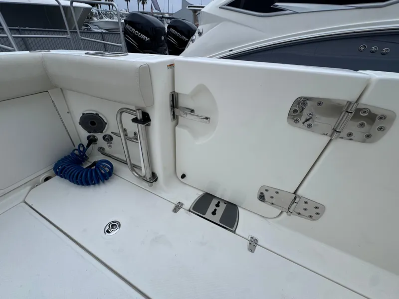 Slide: The Image of Boston Whaler 330 Outrage 2022 boat deck with stainless steel fittings and coiled hose. - 12