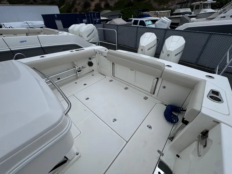 Slide: The Image of 2022 Boston Whaler 330 Outrage boat deck with seating and storage compartments. - 15
