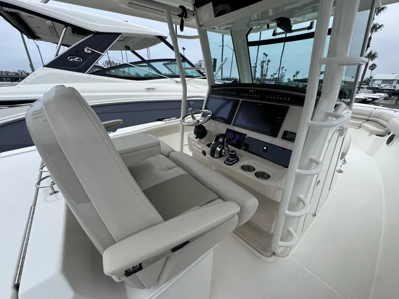 Slide: The Image of 2022 Boston Whaler 330 Outrage helm with modern controls and seating. - 16