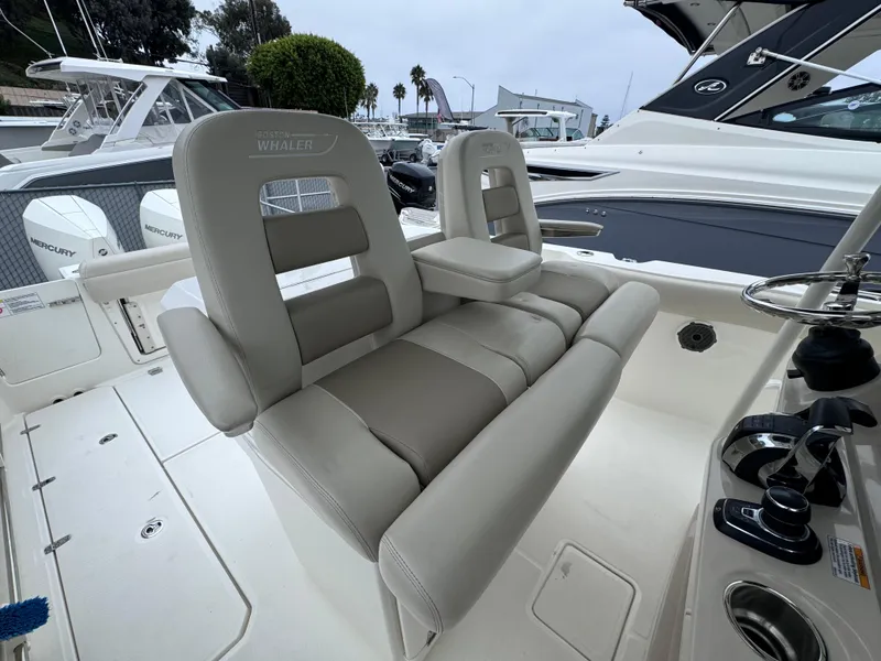 Slide: The Image of 2022 Boston Whaler 330 Outrage boat interior with comfortable seating and modern controls. - 17