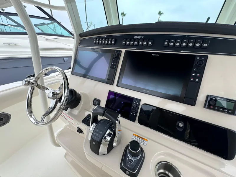 Slide: The Image of 2022 Boston Whaler 330 Outrage helm with advanced navigation displays and controls. - 18
