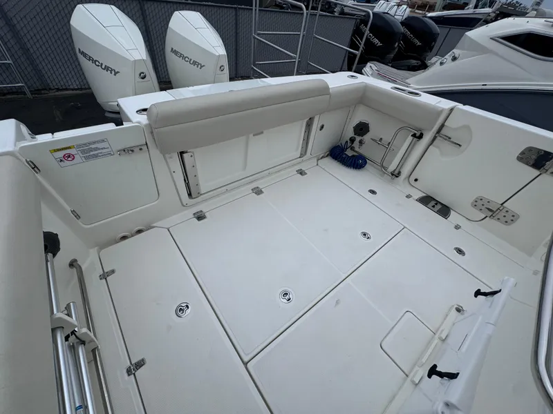 Slide: The Image of 2022 Boston Whaler 330 Outrage boat deck with twin Mercury engines. - 8