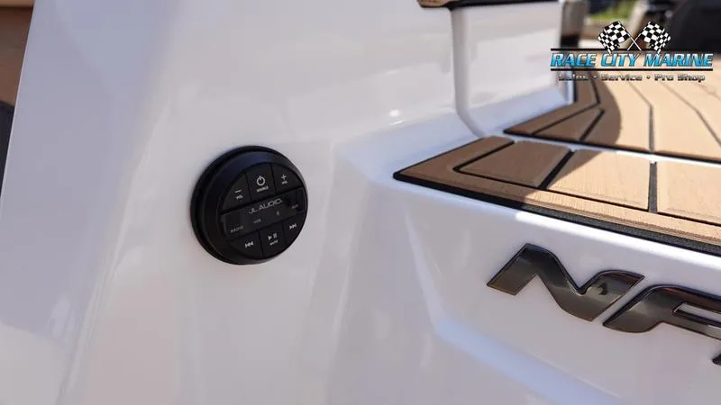 Slide: The Image of 2022 Nautique Super Air Nautique G23 boat detail with audio controls and teak decking. - 14