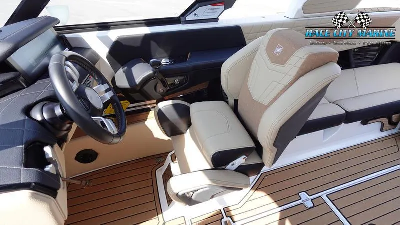 Slide: The Image of 2022 Nautique Super Air Nautique G23 interior with beige seating and wood-style flooring. - 28