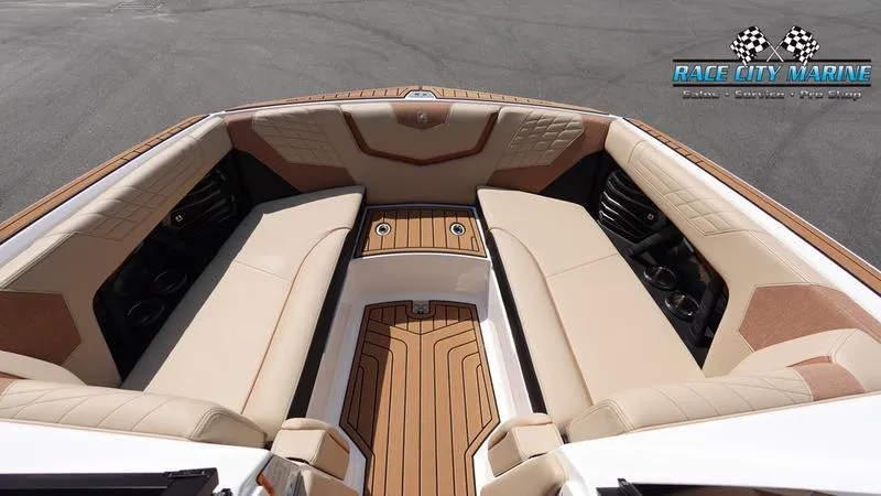 Slide: The Image of 2022 Nautique Super Air Nautique G23 boat interior with beige seating and wood accents. - 49