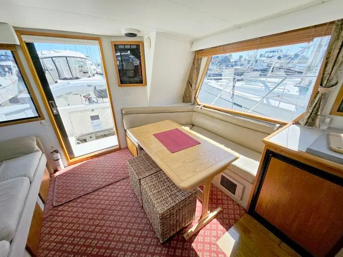 Slide: The Image of Interior of 1993 Navigator 4300 yacht with dining area and marina view. - 10