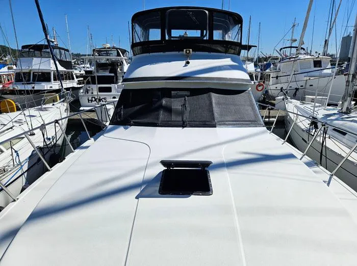 Slide: The Image of 1993 Navigator 4300 yacht docked in a marina, surrounded by other boats. - 2