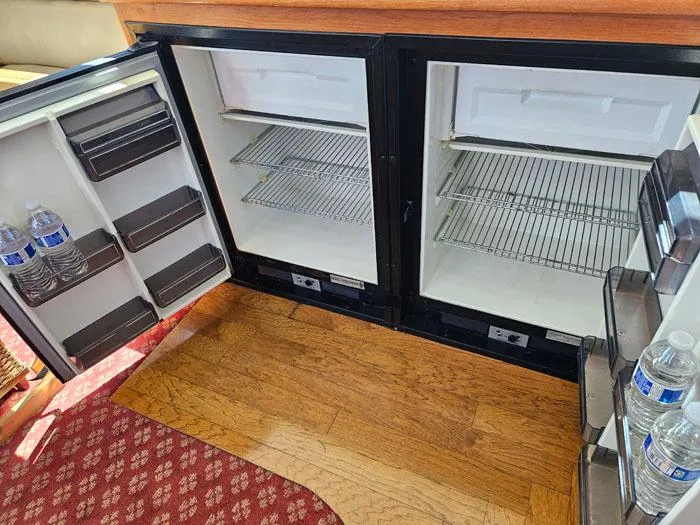 Slide: The Image of Open mini fridge with water bottles, wooden floor, and red patterned carpet. Navigator 4300, 1993. - 21