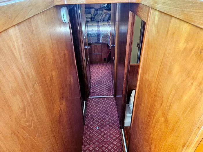 Slide: The Image of Narrow hallway inside 1993 Navigator 4300 boat with wooden walls and red carpet. - 22