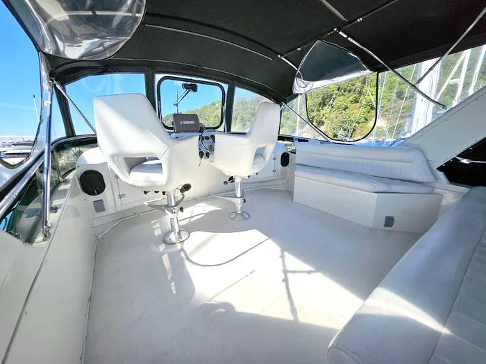 Slide: The Image of Interior of a 1993 Navigator 4300 yacht with white seating and helm. - 29