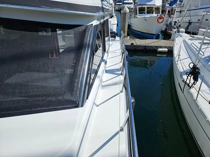 Slide: The Image of 1993 Navigator 4300 yacht docked at marina, side view with railing and water. - 3