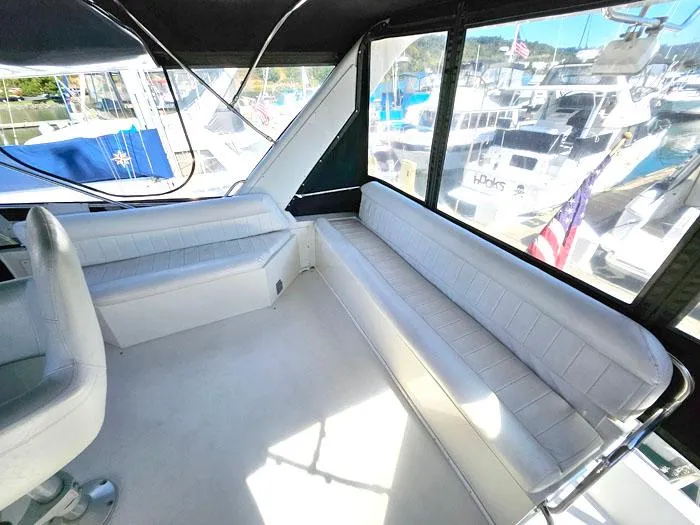 Slide: The Image of Interior of 1993 Navigator 4300 yacht with white seating and marina view. - 30
