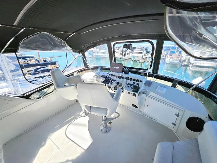 Slide: The Image of Cockpit of 1993 Navigator 4300 yacht with white seating and marina view. - 31