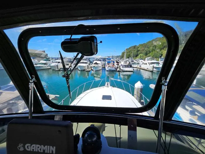 Slide: The Image of View from Navigator 4300 boat cockpit, overlooking marina with docked boats, clear blue sky. - 33
