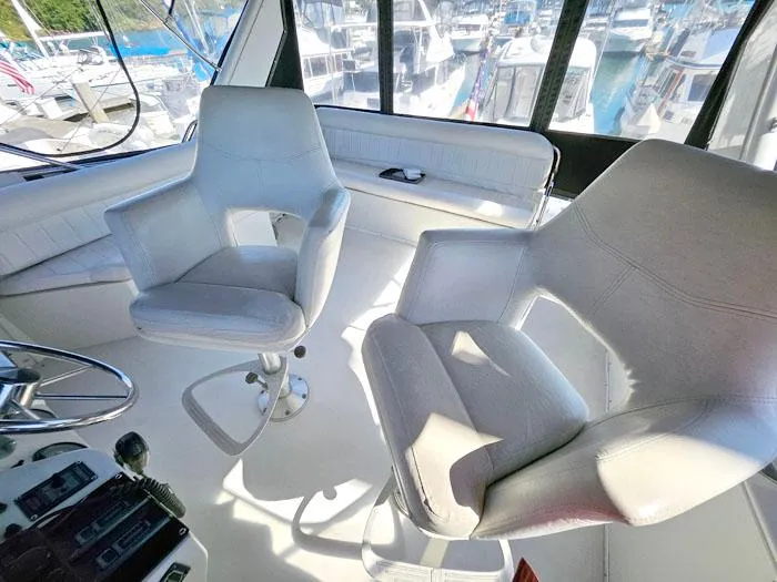 Slide: The Image of Interior of 1993 Navigator 4300 yacht with white captain chairs and marina view. - 34