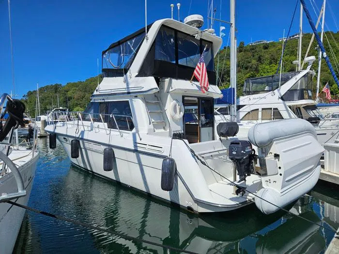 Slide: The Image of 1993 Navigator 4300 yacht docked, featuring a sleek design and American flag. - 41