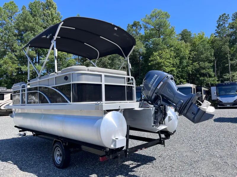 Slide: The Image of 2021 Bennington SV 20 Quad Bench pontoon boat with Yamaha outboard motor, parked outdoors. - 3