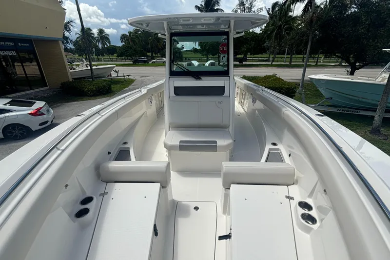 Slide: The Image of 2025 Sailfish 312 CC boat interior with seating and console, parked outdoors. - 13