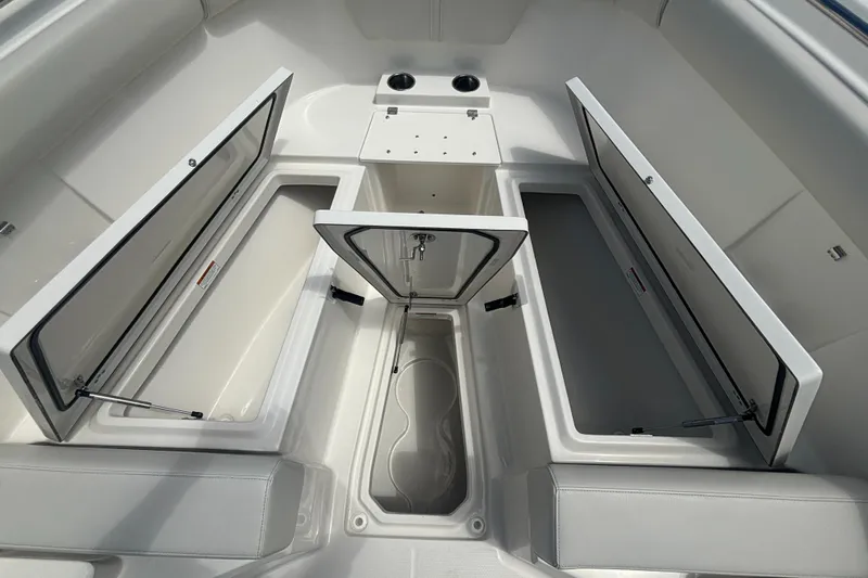 Slide: The Image of 2025 Sailfish 312 CC boat interior with open storage compartments and cup holders. - 14