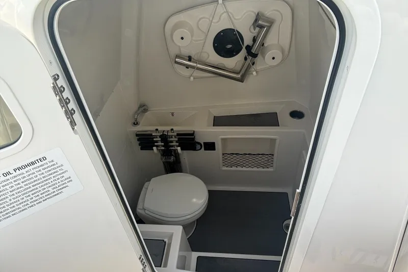 Slide: The Image of 2025 Sailfish 312 CC boat interior with compact bathroom and toilet. - 18