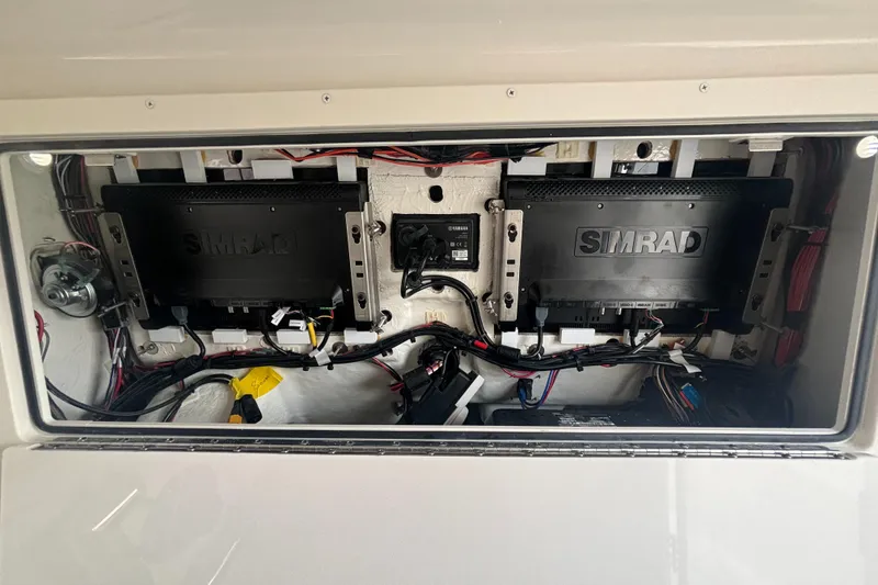 Slide: The Image of 2025 Sailfish 312 CC electronics compartment with Simrad systems and wiring. - 19