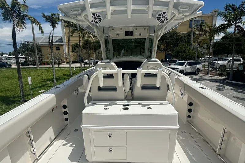Slide: The Image of 2025 Sailfish 312 CC boat interior with seating and storage, parked outdoors. - 26