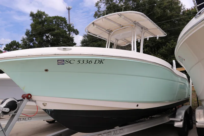 Slide: The Image of 2018 Robalo R202 Explorer boat on trailer, light blue hull, parked outdoors. - 2