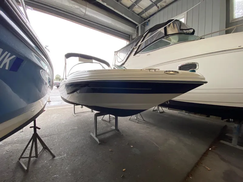 Slide: The Image of 2005 Sea Ray 180 Sport boat in storage, surrounded by other vessels. - 2