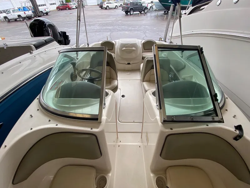 Slide: The Image of 2005 Sea Ray 180 Sport boat interior with seating and steering wheel, parked in a marina. - 5