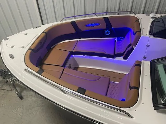 Slide: The Image of 2025 Chaparral 30 Surf boat interior with tan seating and blue LED lighting. - 10