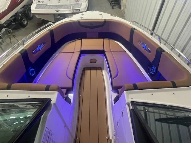 Slide: The Image of 2025 Chaparral 30 Surf boat interior with ambient blue lighting and cushioned seating. - 13