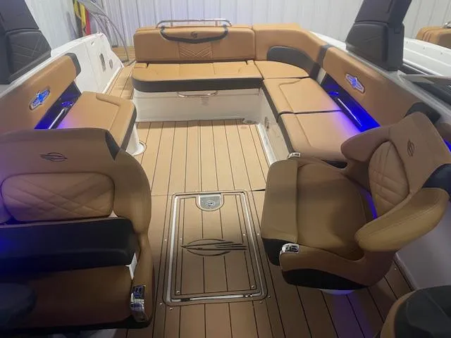 Slide: The Image of 2025 Chaparral 30 Surf boat interior with tan seating and blue accent lighting. - 14