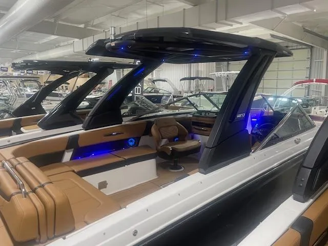 Slide: The Image of 2025 Chaparral 30 Surf boat interior with modern seating and blue LED lighting. - 16