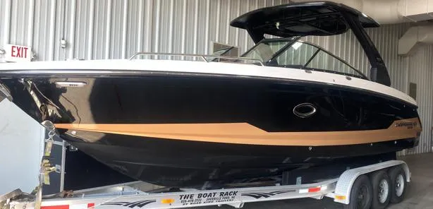 Slide: The Image of 2025 Chaparral 30 Surf boat on trailer in storage facility. - 2