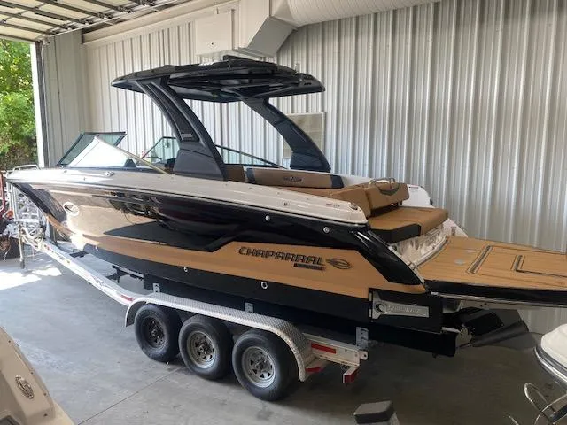 Slide: The Image of 2025 Chaparral 30 Surf boat on trailer in garage. - 3