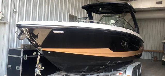 Slide: The Image of 2025 Chaparral 30 Surf boat in storage, black and gold design. - 4
