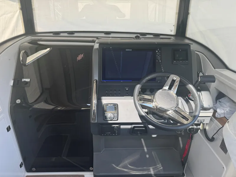 Slide: The Image of 2024 Nimbus Commuter 9 boat cockpit with modern steering and navigation system. - 10
