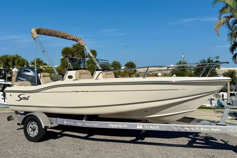 The Image of 2024 Scout 175 Sport Dorado boat on trailer, featuring Yamaha engine, parked outdoors. - 0