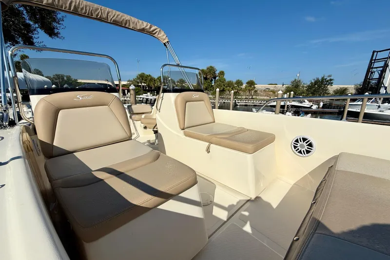 Slide: The Image of 2024 Scout 175 Sport Dorado boat interior with beige seating and clear skies. - 11