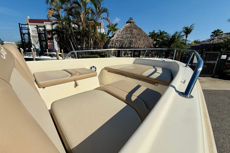 Slide: The Image of 2024 Scout 175 Sport Dorado boat interior with beige seating, palm trees in background. - 12