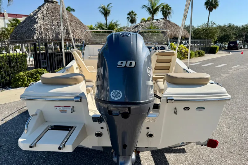 Slide: The Image of 2024 Scout 175 Sport Dorado boat with Yamaha 90 engine, parked near tropical setting. - 4