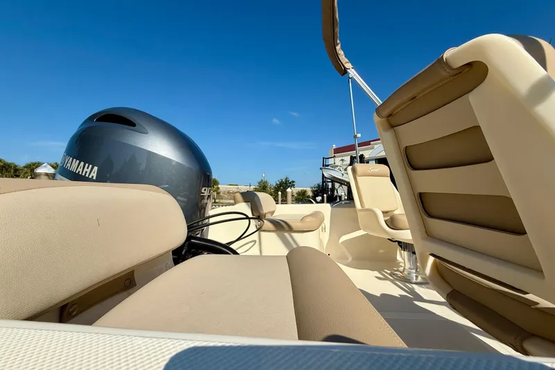 Slide: The Image of 2024 Scout 175 Sport Dorado boat interior with Yamaha engine, beige seating, and clear blue sky. - 6