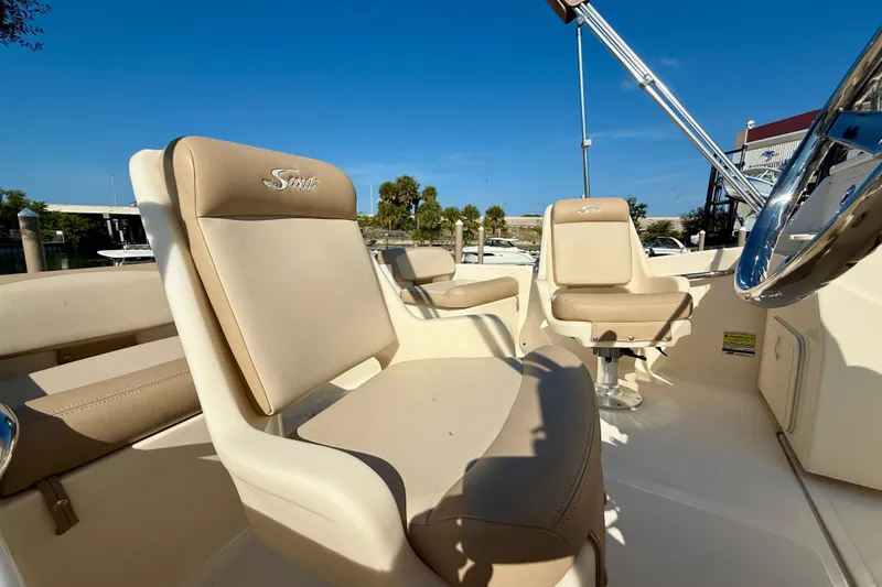 Slide: The Image of 2024 Scout 175 Sport Dorado boat interior with beige seating and steering wheel. - 8