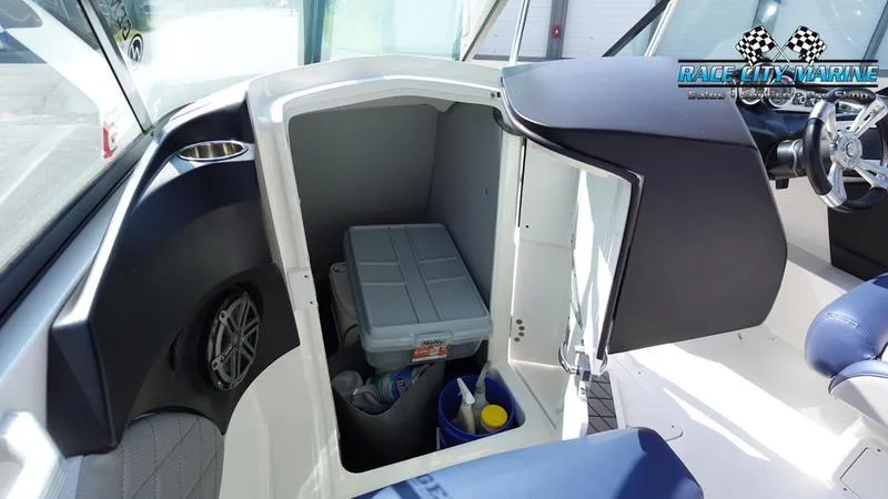 Slide: The Image of 2015 MasterCraft X55 boat interior storage compartment with cleaning supplies and cooler. - 16
