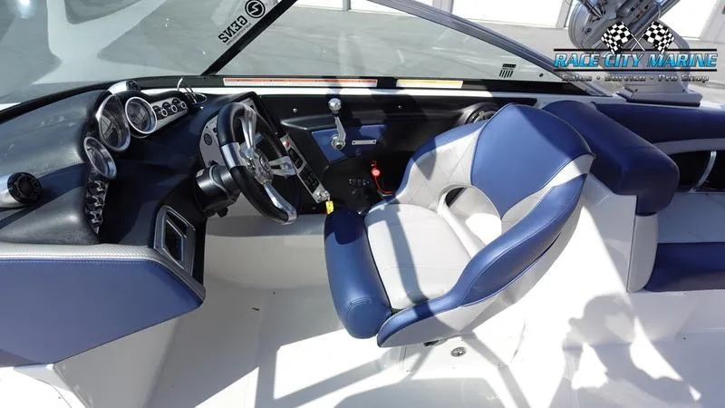 Slide: The Image of 2015 MasterCraft X55 boat interior with blue and white seating and dashboard controls. - 21